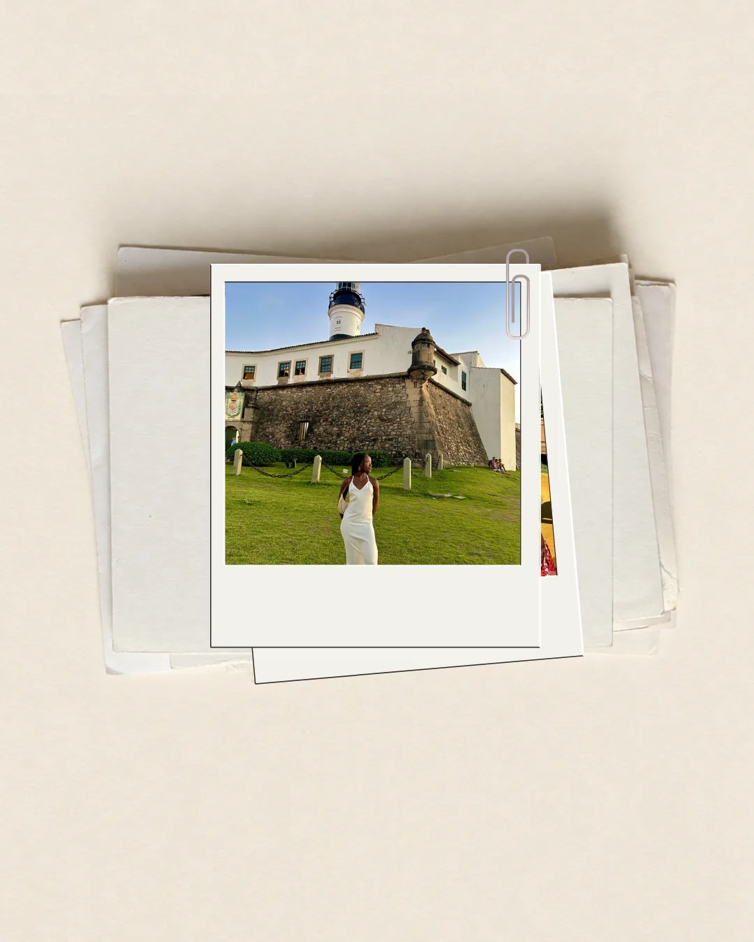 Polaroid com uma fotografia diante do Farol da Barra, sobre papéis antigos